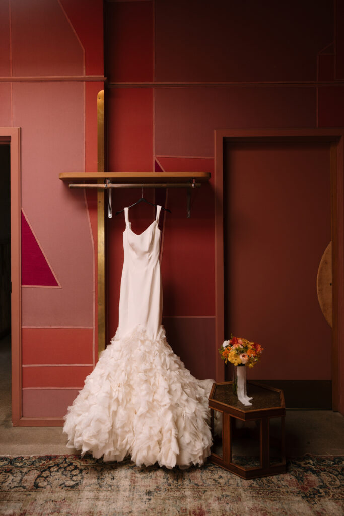 Ines di Santo Nygie couture wedding gown hung in red bridal suite at the Grass Room DTLA