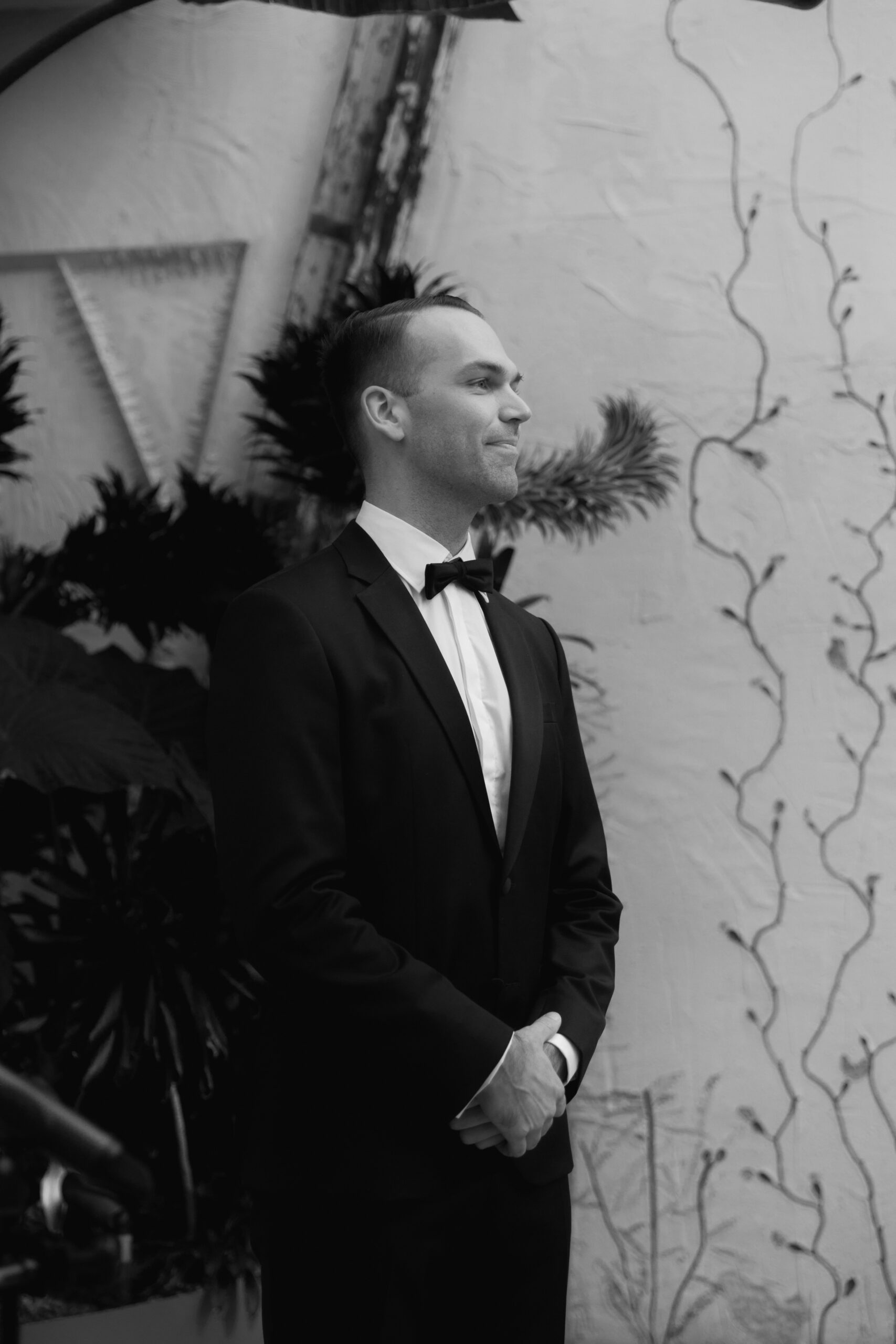 black and white photo of groom waiting for his bride to walk down the aisle