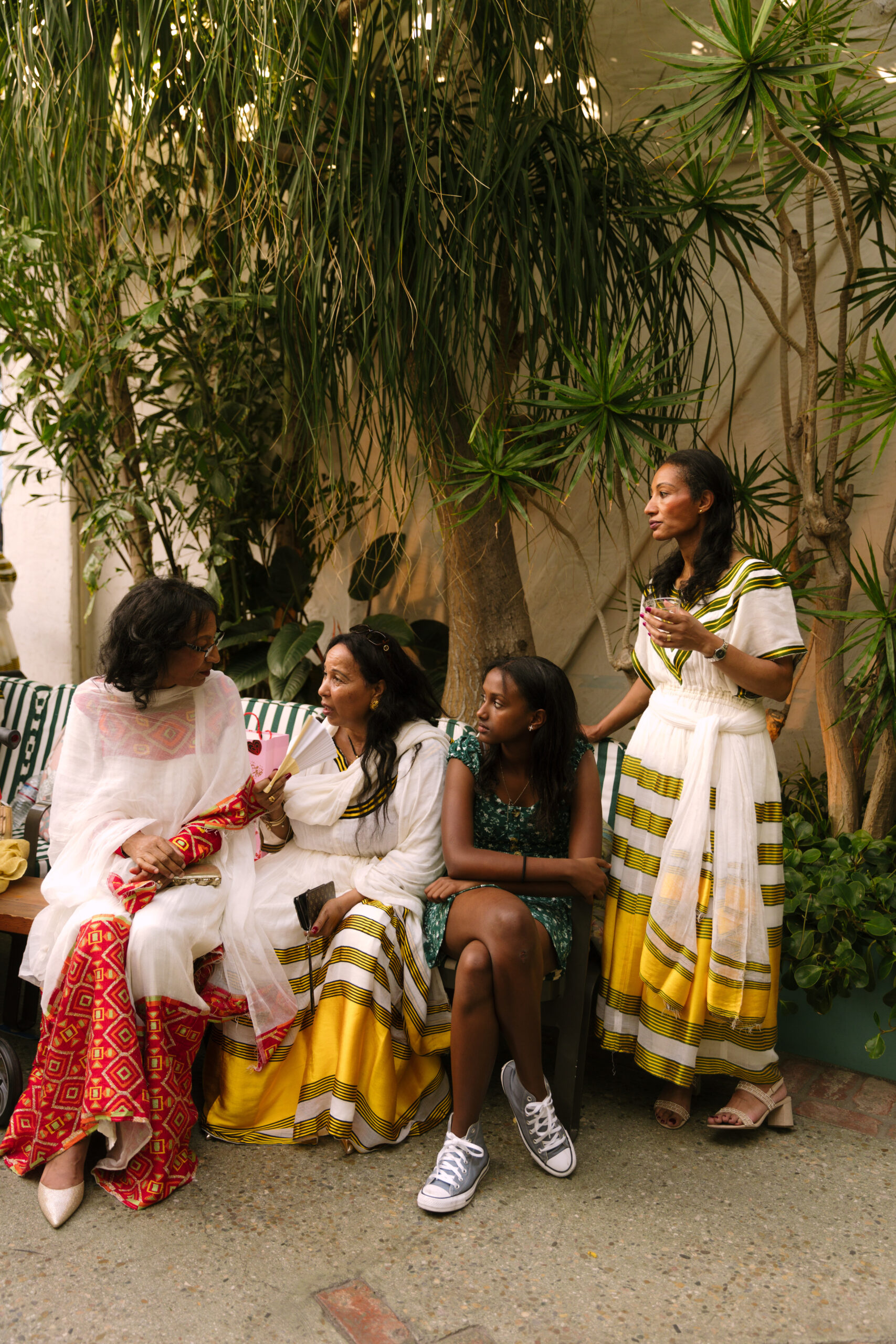 female family members sitting and catching up during cocktail hour wearing traditional Ethiopian Habesha kemis