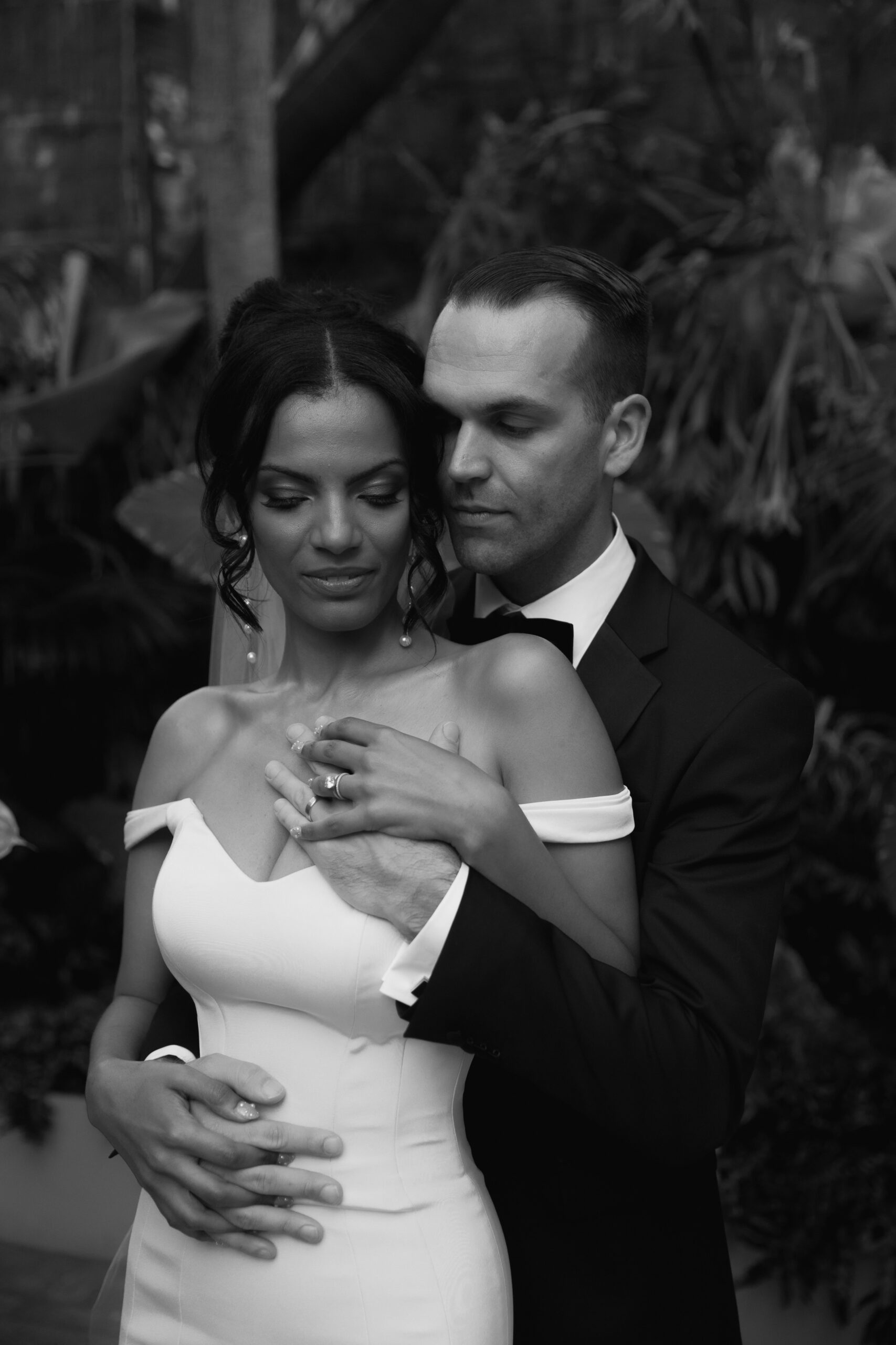 black and white photo of groom and bride back to front as he pulls her in for an embrace