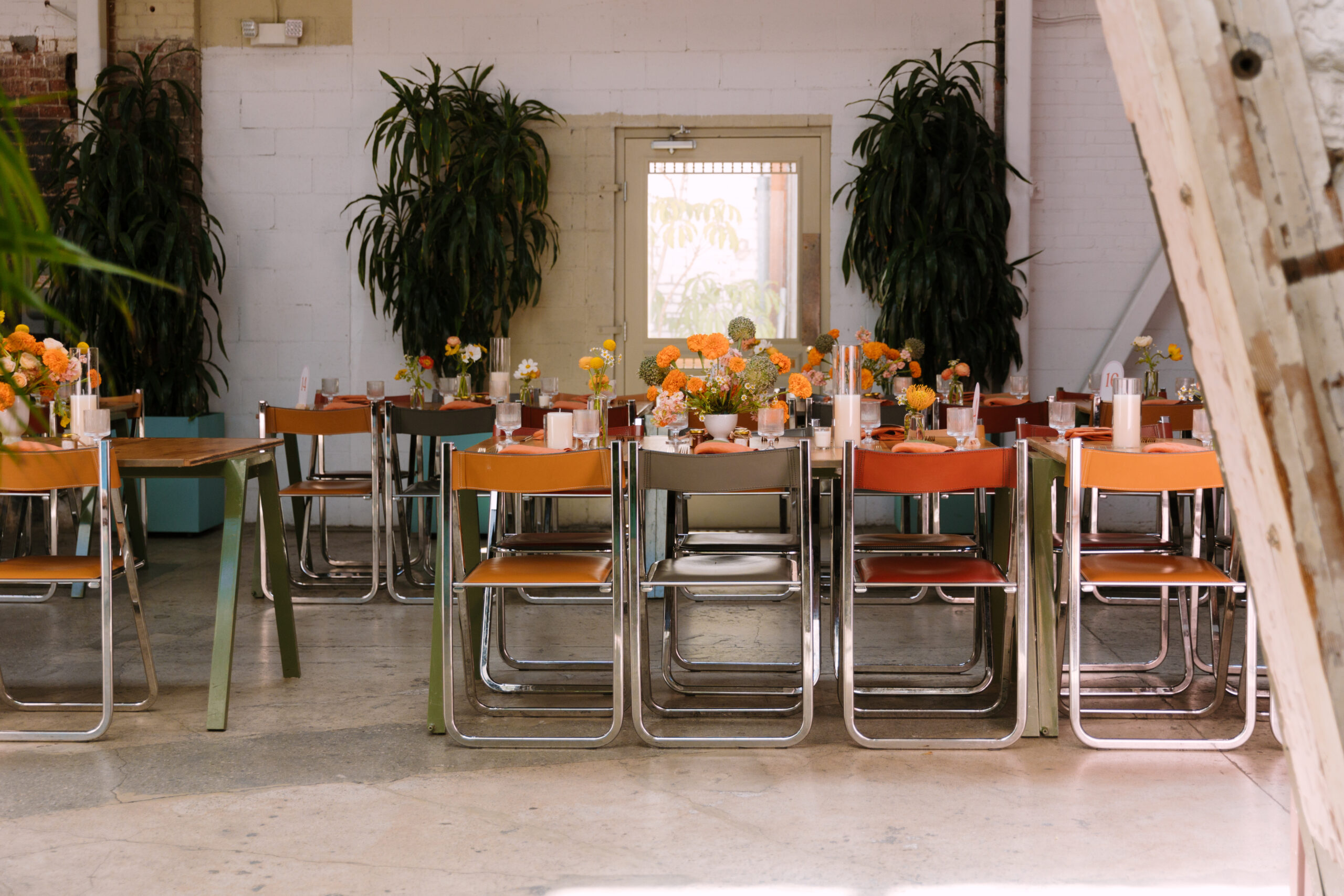reception tablescape with orange tropical flowers and Italian leather Arrben chairs at the Grass Room DTLA