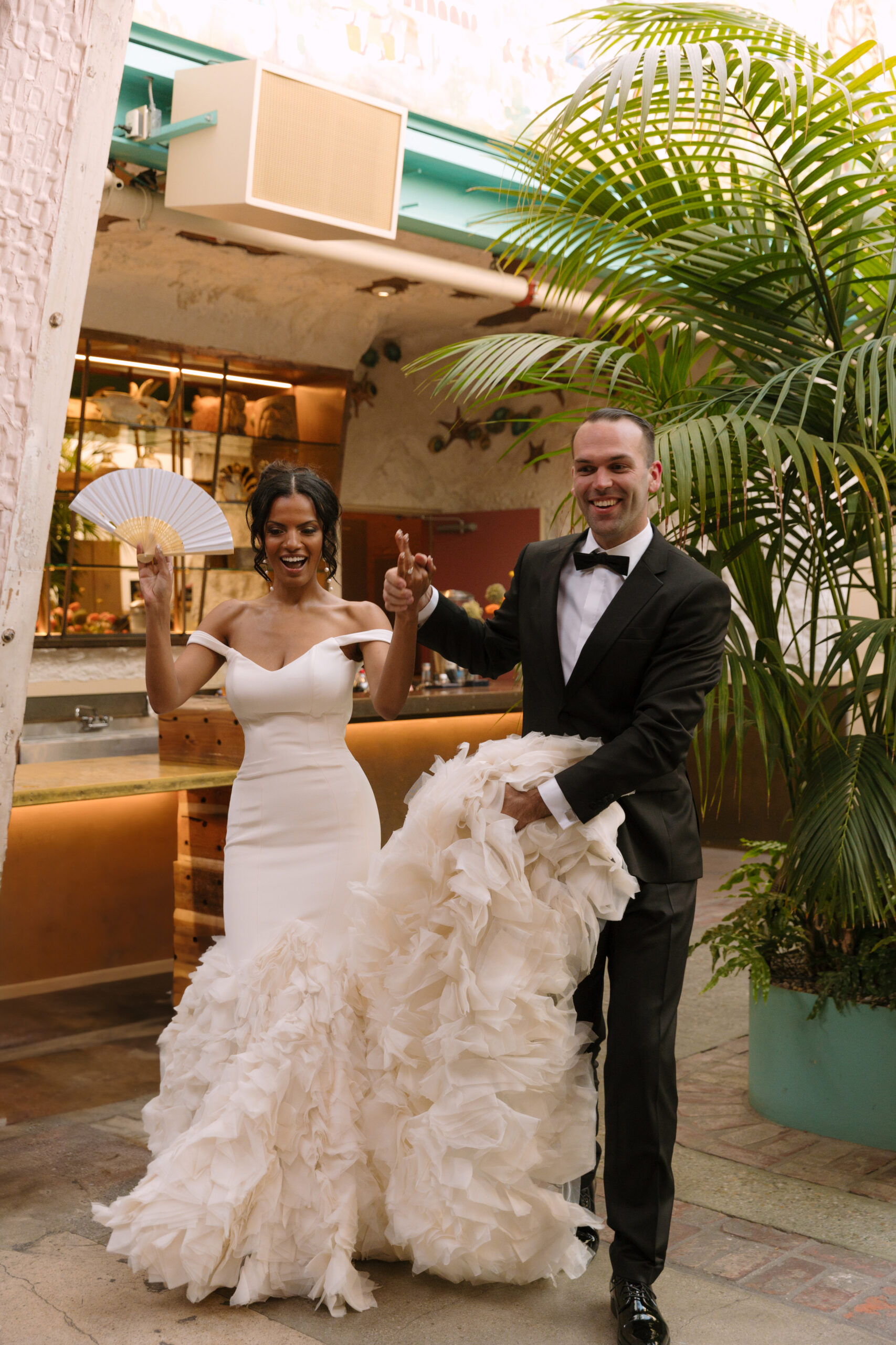 Black bride and white groom making grand entrance into reception space at the Grass Room DTLA