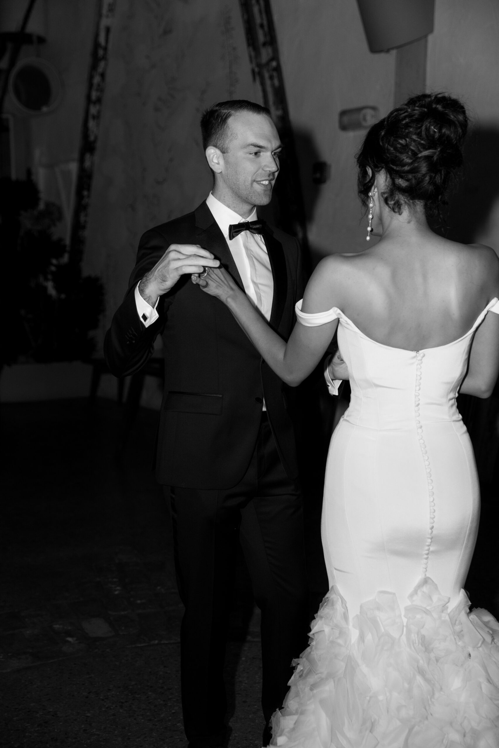 black and white cloesup direct flash portrait of groom about to twirl bride during their first dance