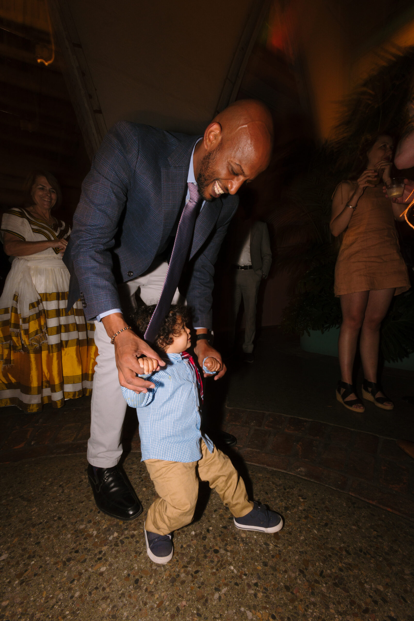 direct flash photo of father dancing with his baby during wedding reception