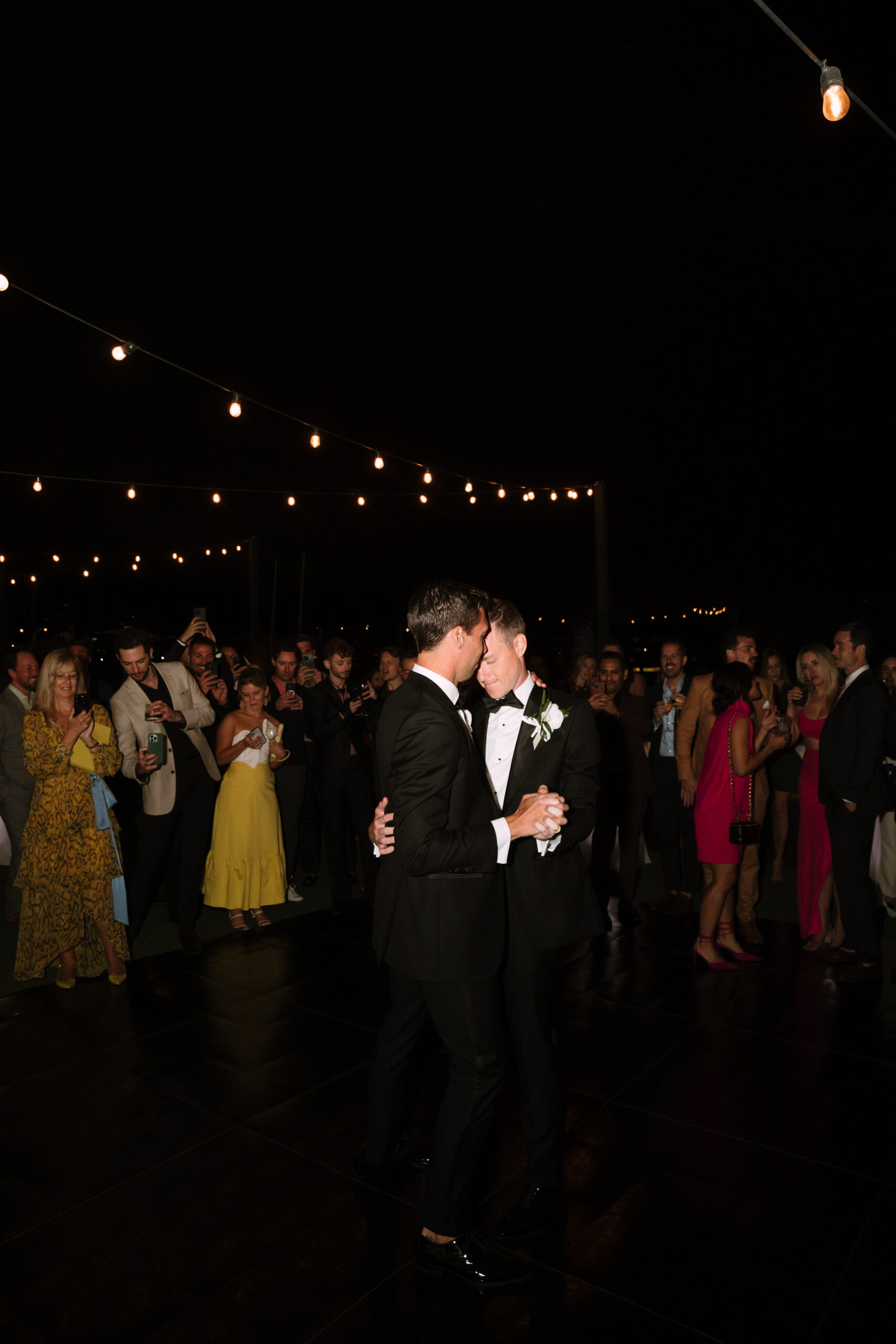 direct flash photo of gay grooms sharing their first dance