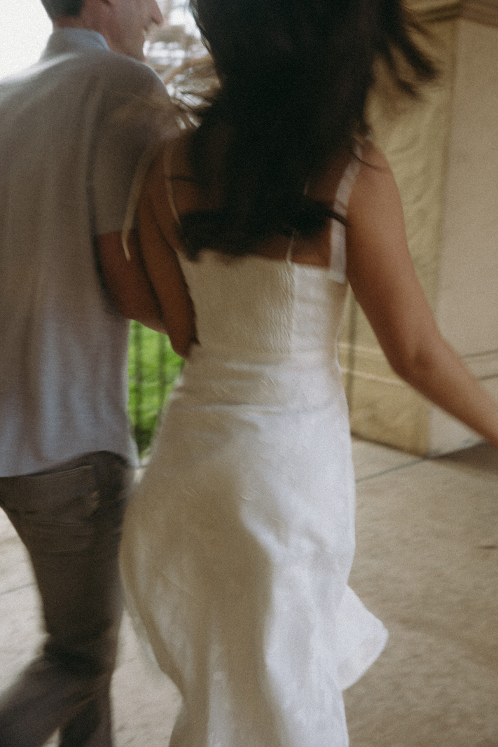 blurry photo of couple running through covered courtyard of Casa del Prado at Balboa Park