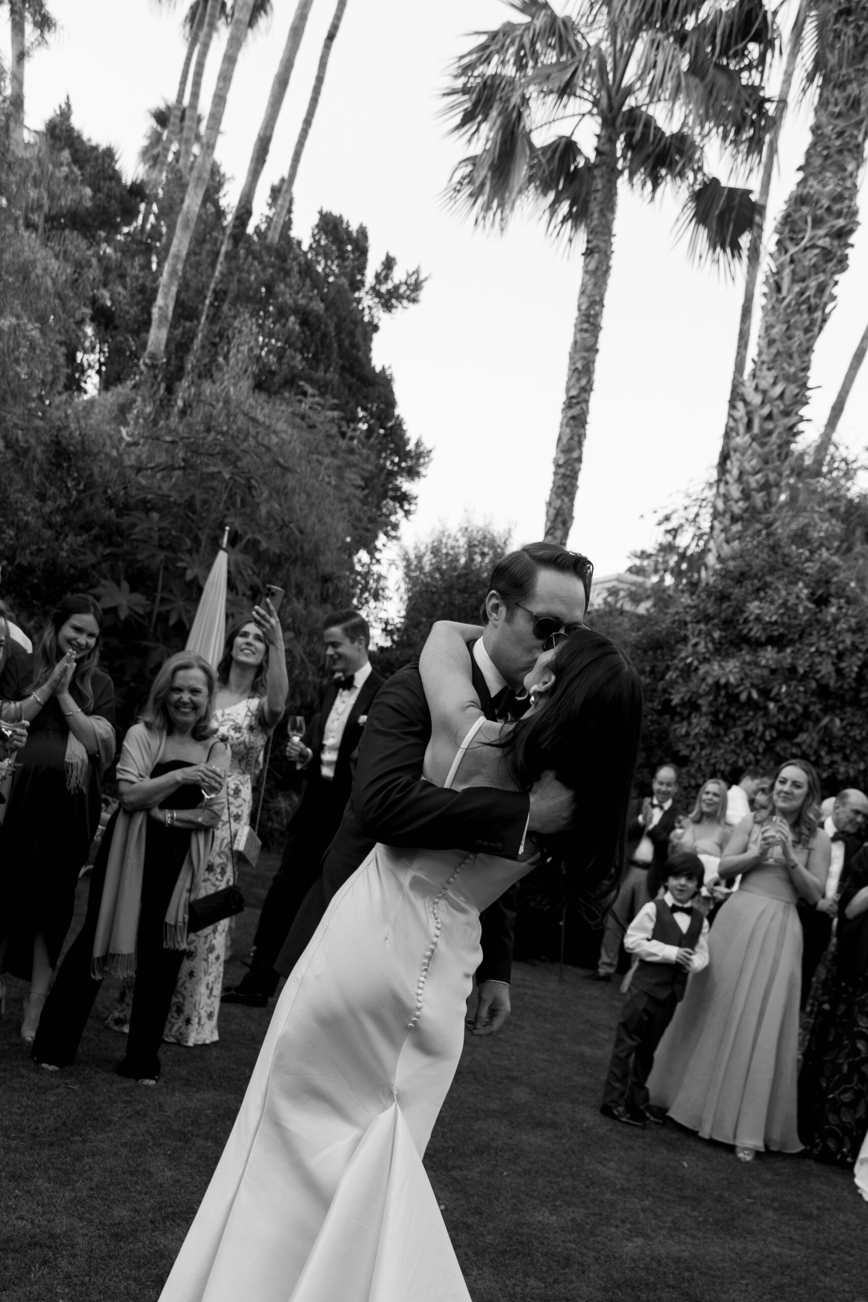 bride and groom kissing as they enter croquet lawn at Parker for their cocktail hour