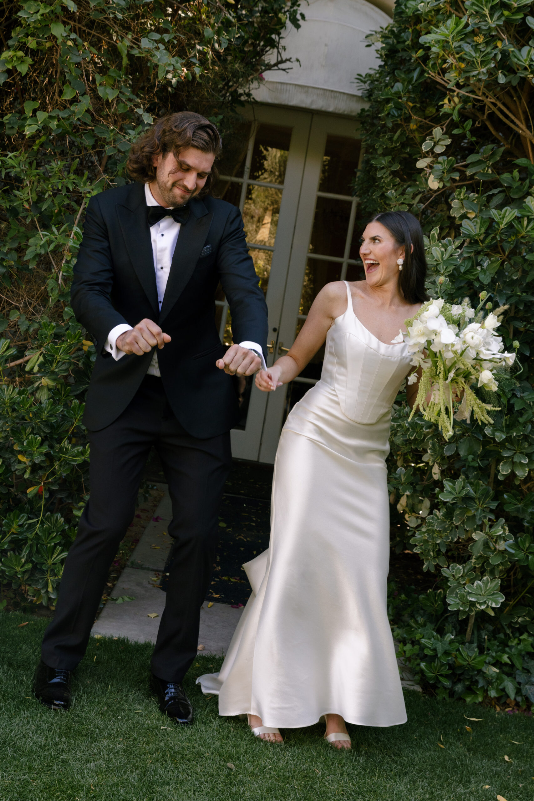 bride and brother dancing together during family photos at Parker Palm Springs