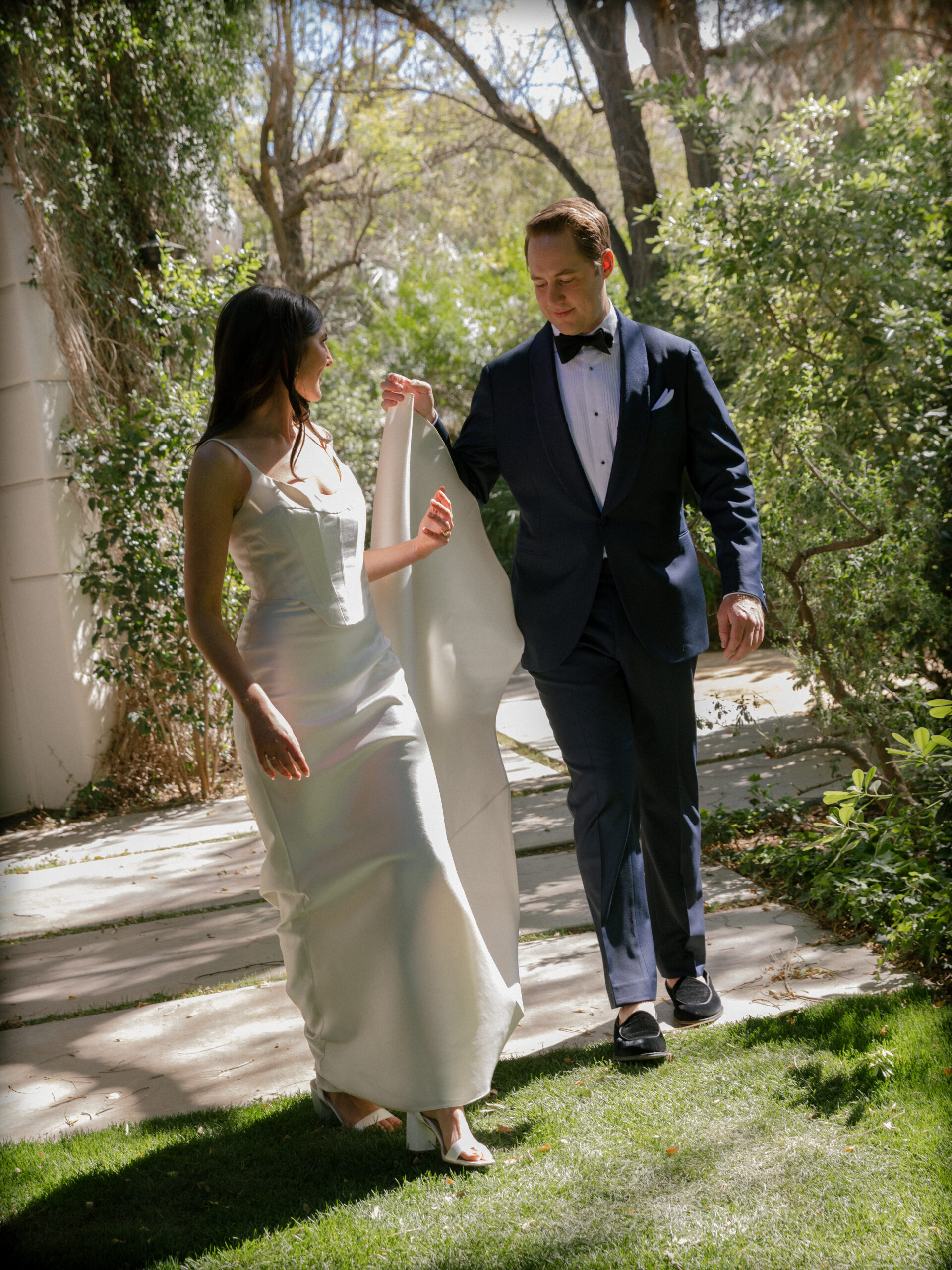 film photo of groom helping bride with train of her dress at Parker Palm Springs