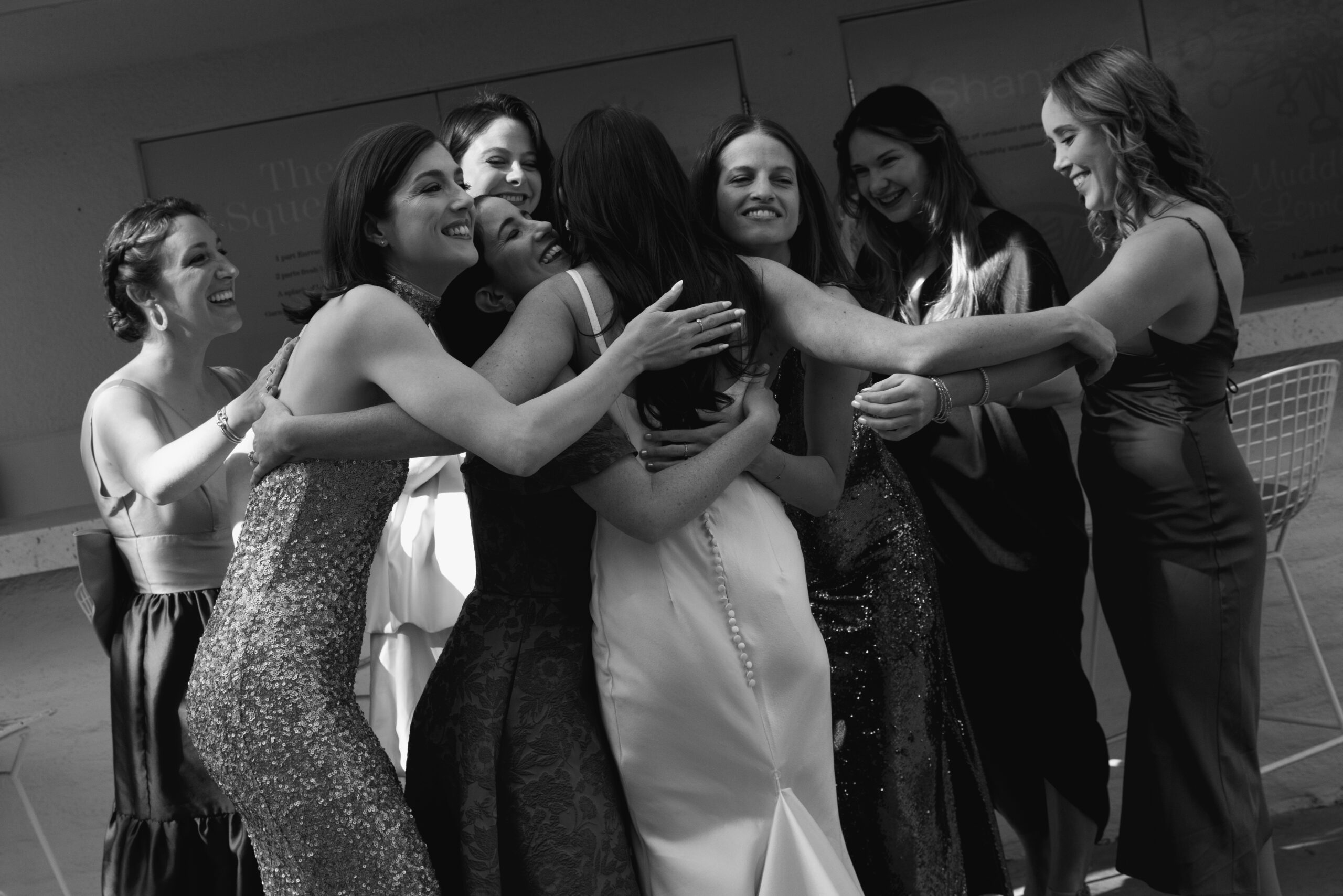 black and white photo of bride hugging friends during first look at Parker Palm Springs