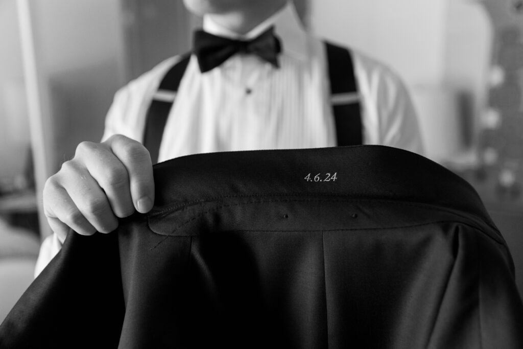 black and white close-up of wedding date detail embroidered on groom's jacket