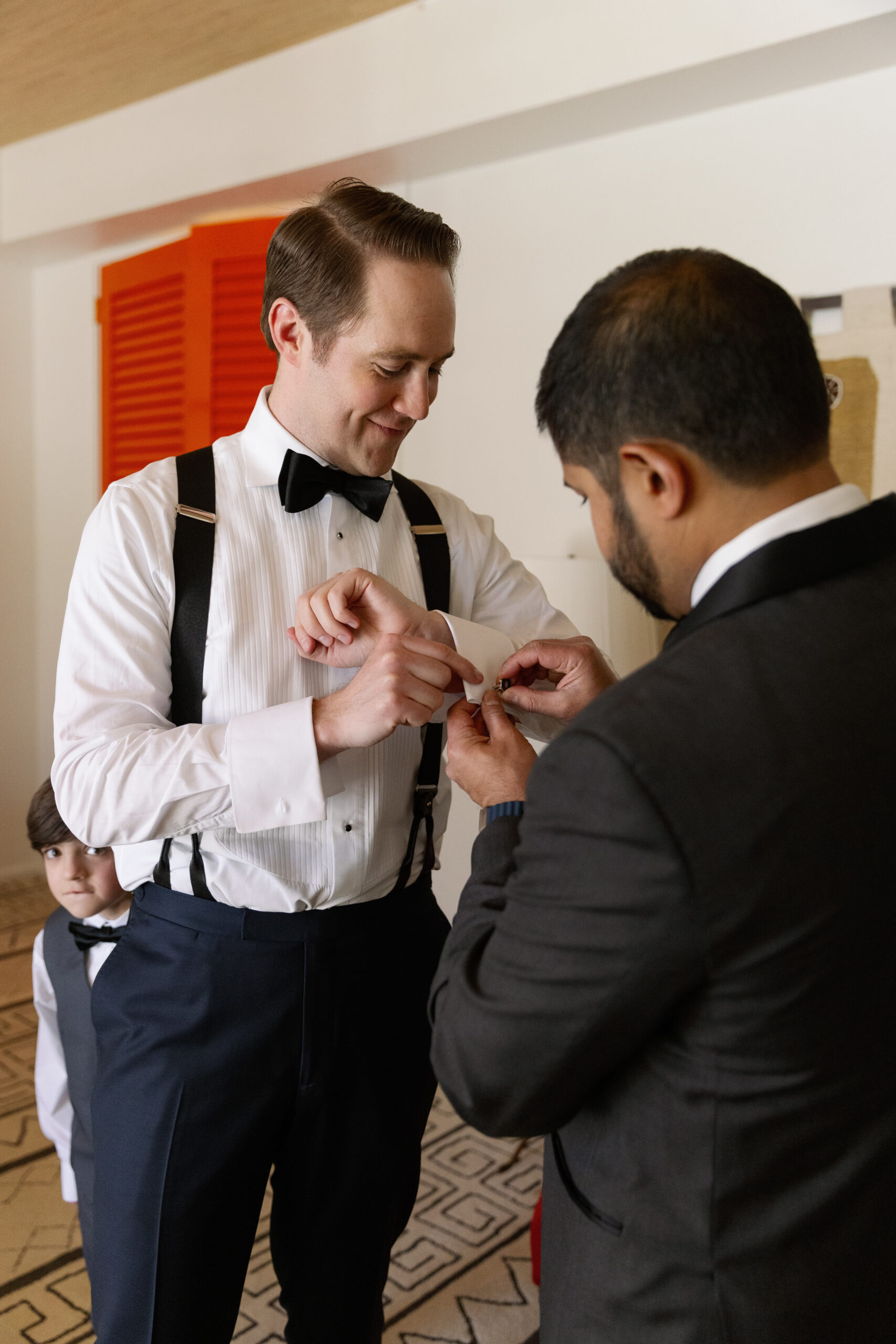 groom's officiant helping him adjust his cufflinks