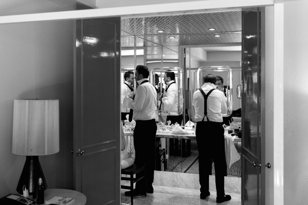 black and white photo of groom and best man getting ready in bathroom of Parker Palm Springs villa