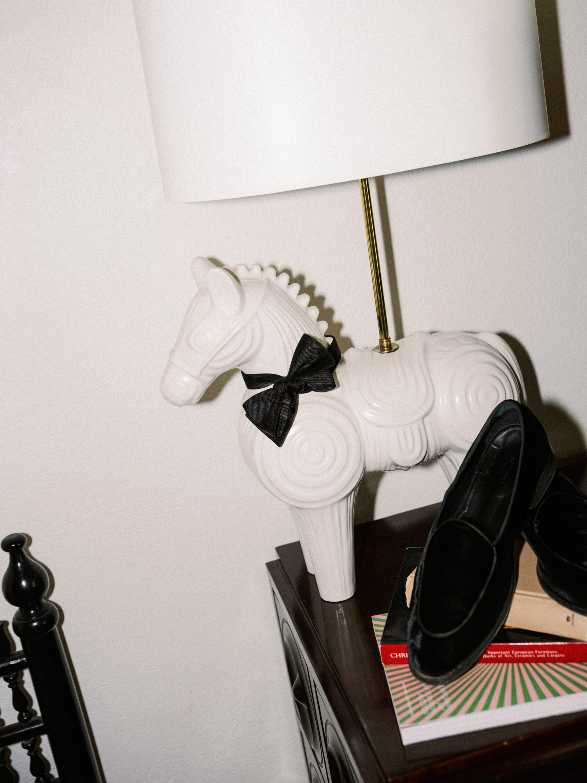 flash photo of white pony lamp wearing black bow tie