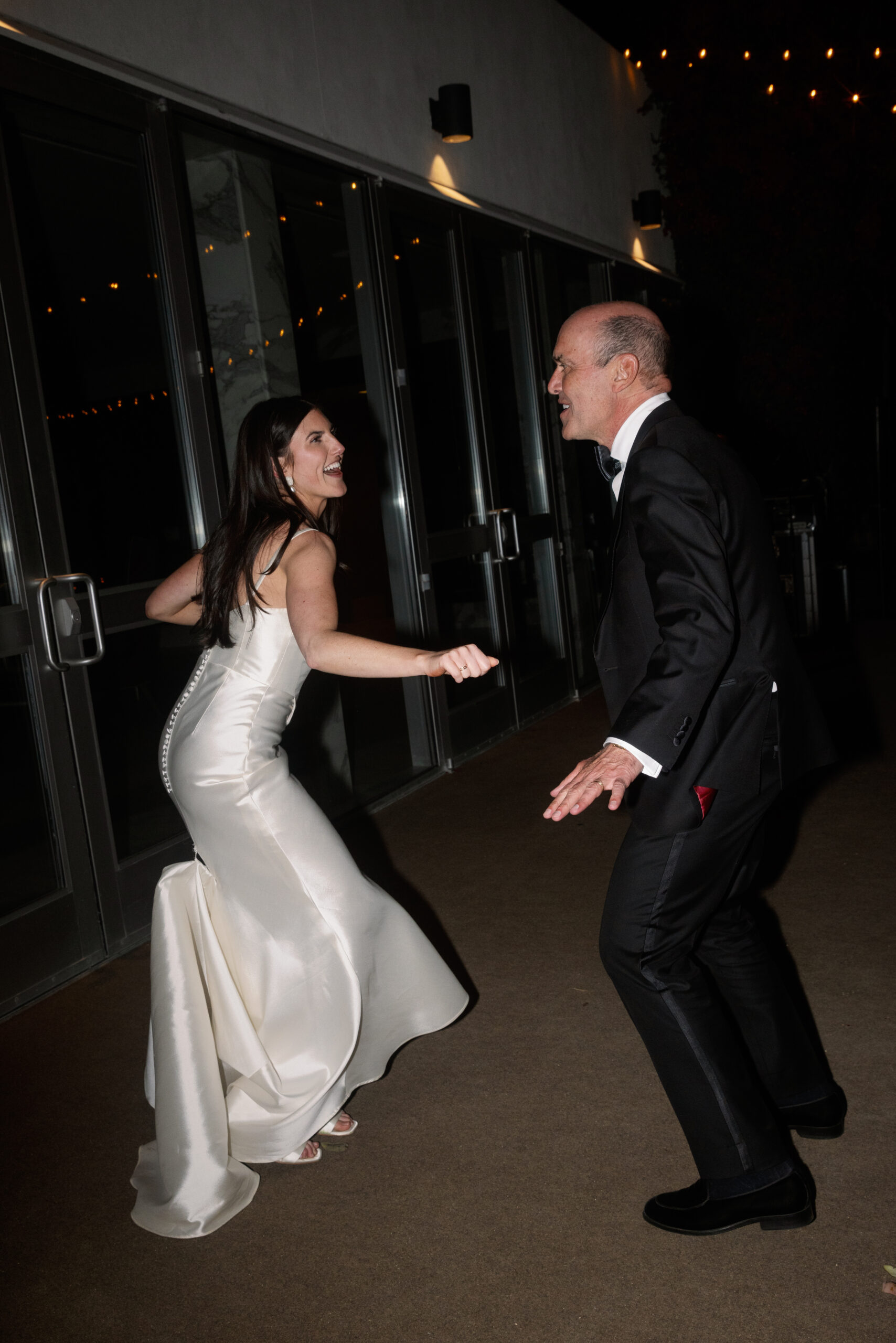 flash photo of father and daughter doing silly dance together