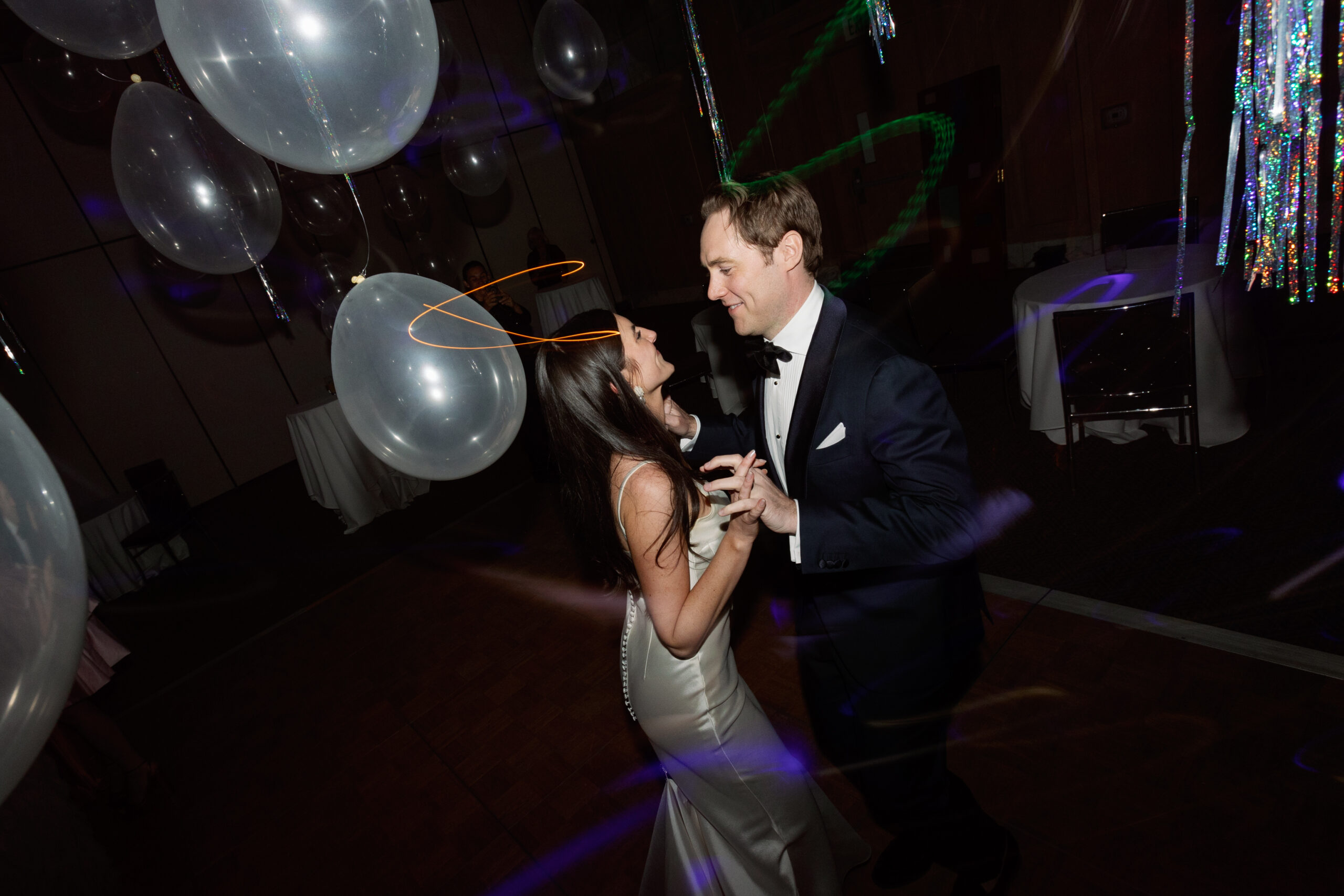 direct flash wide photo of bride and groom dancing under balloons in Parker Palm Springs banquet room