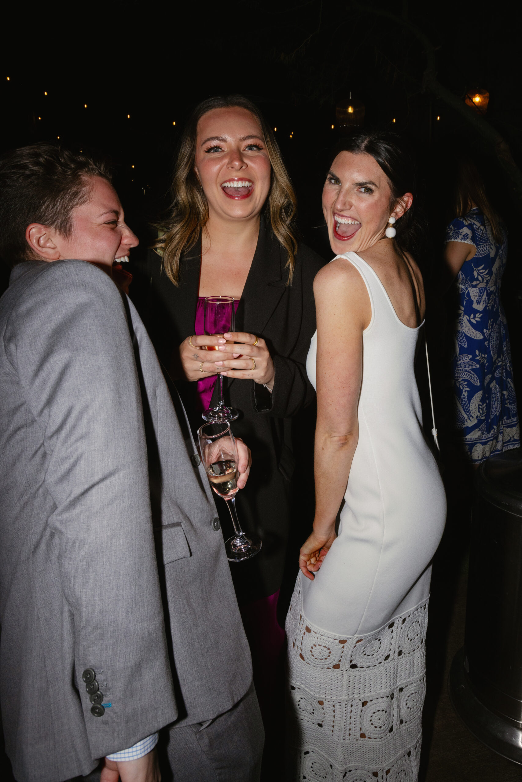 flash photo of bride laughing with friends on patio at Eight4Nine welcome reception