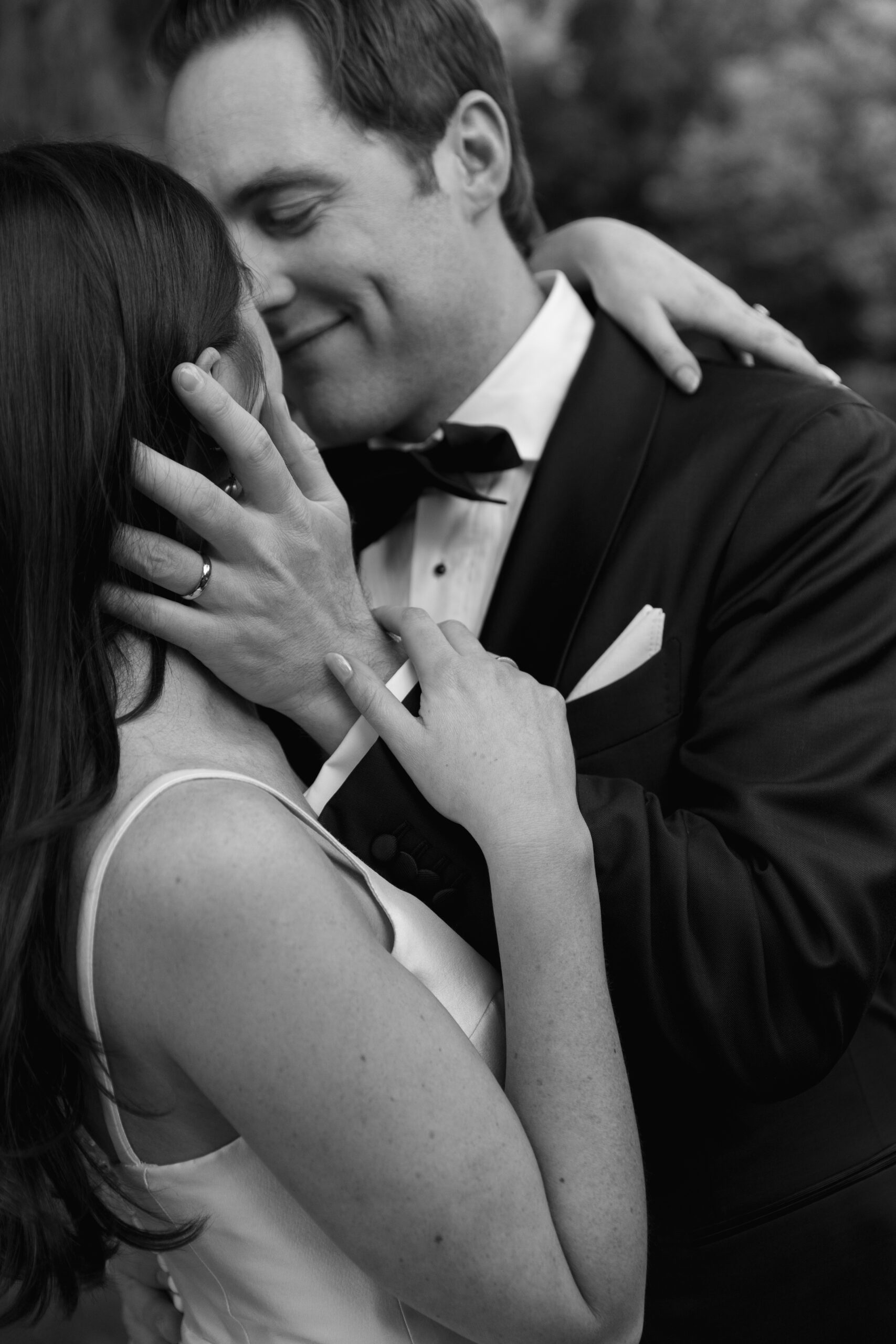 black and white close-up of groom holding bride's face at Parker