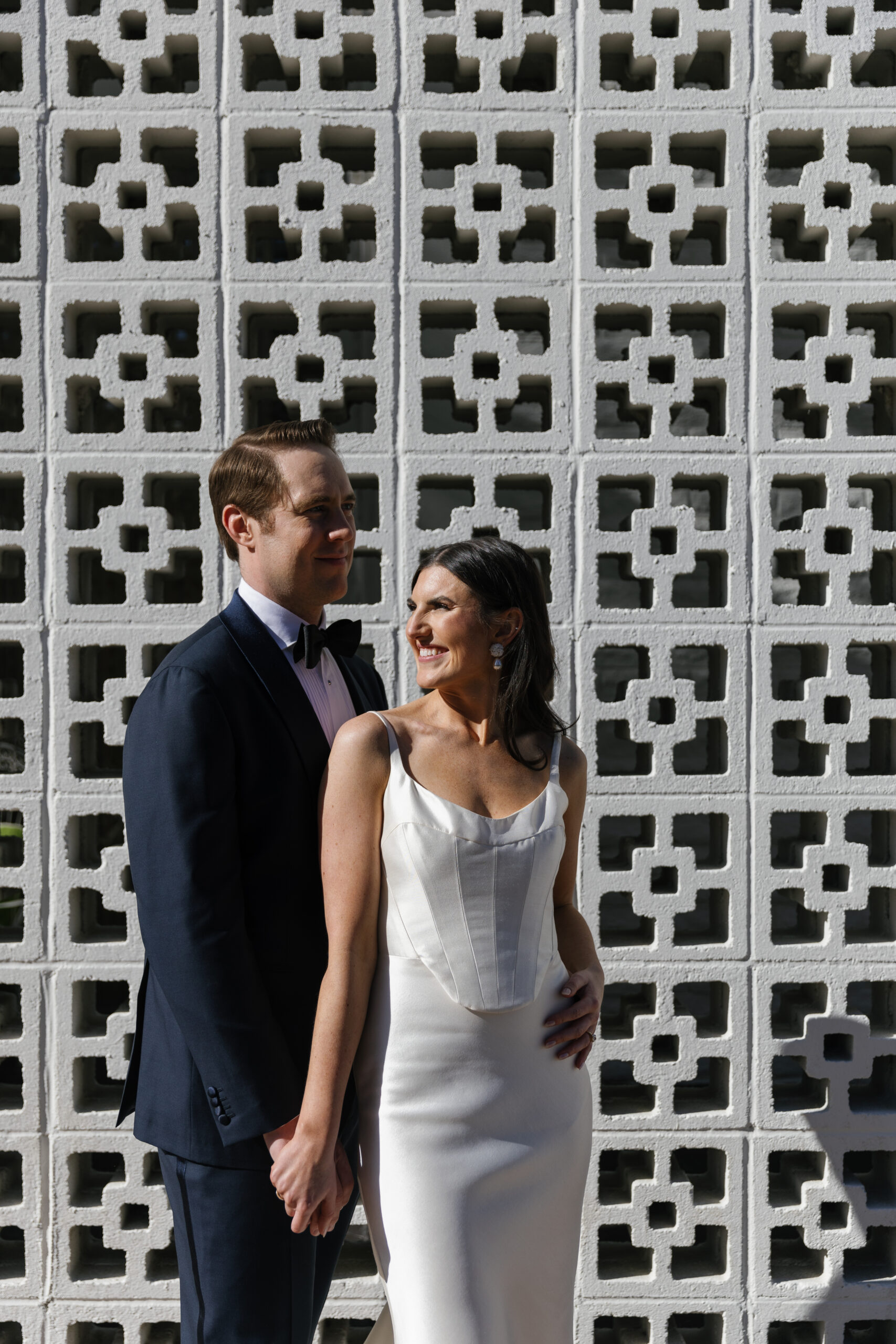 groom with arms around bride in front of Parker Palm Springs entrance bricks