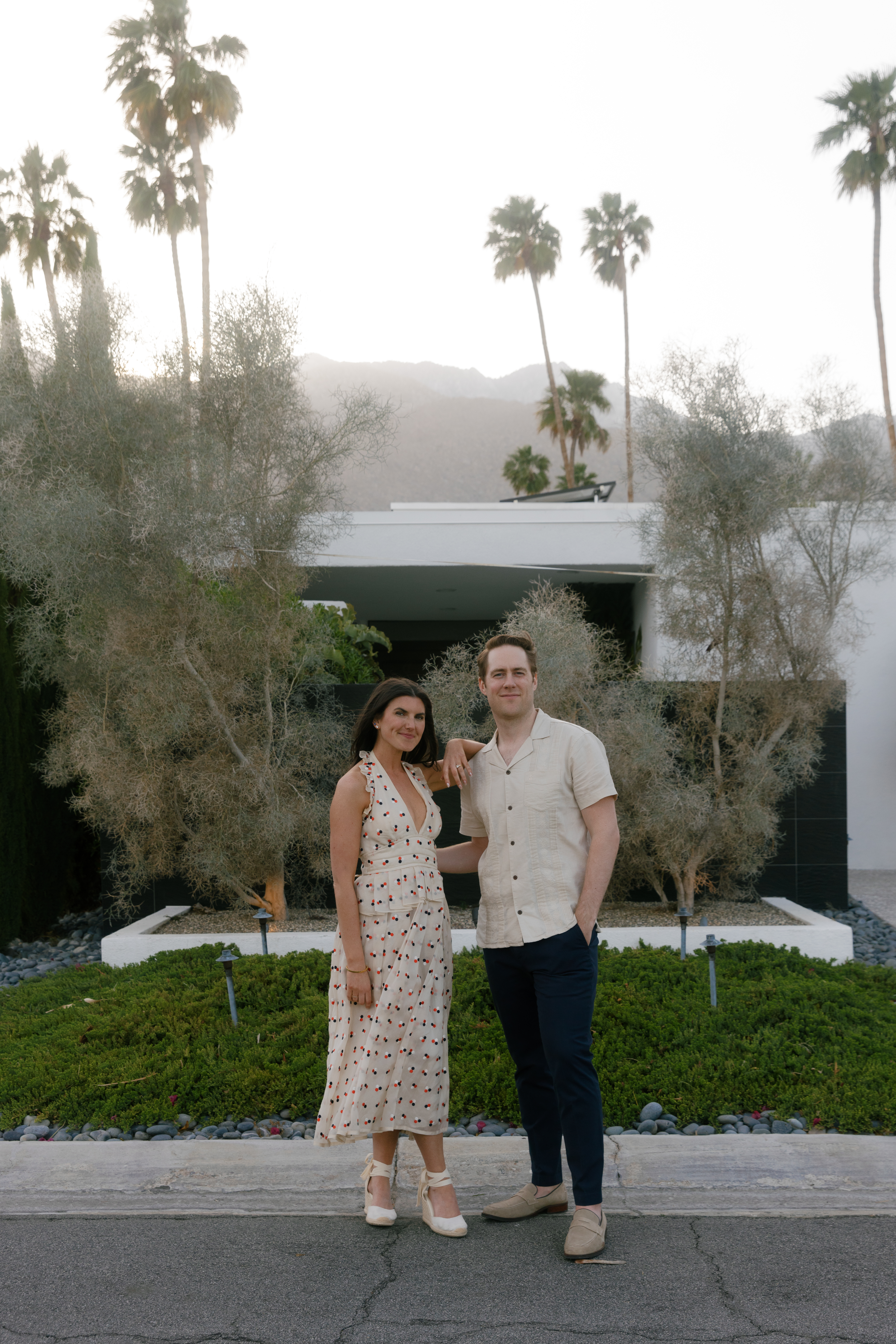 couple standing in front of Palm Springs home at dusk